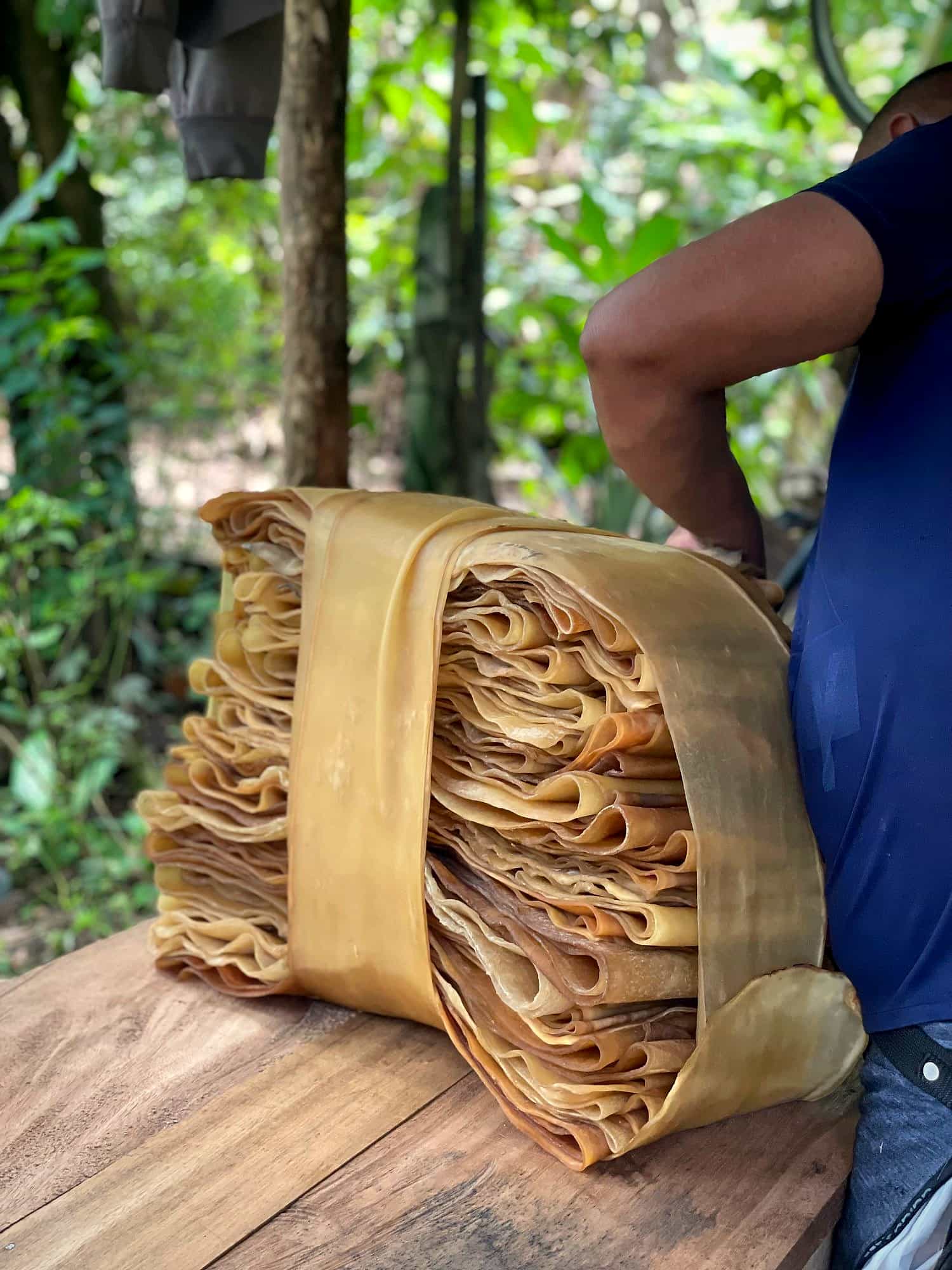Productor organiza un fardo de láminas de caucho natural